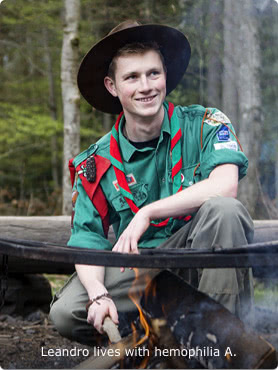 Leandro, who lives with hemophilia A Full-length shot of Leandro, who lives with hemophilia A, as he crouches down to start a fire at an outdoor campsite